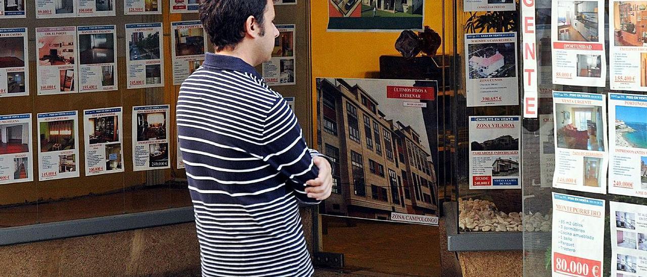Un joven observa los anuncios de una inmobiliaria en Pontevedra.   | // RAFA VÁZQUEZ