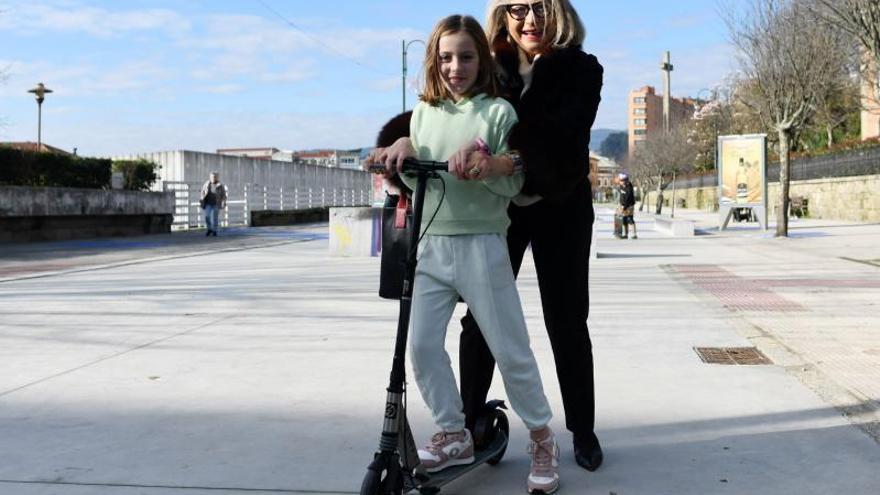 Una niña y su abuela juegan con un patinete nuevo.