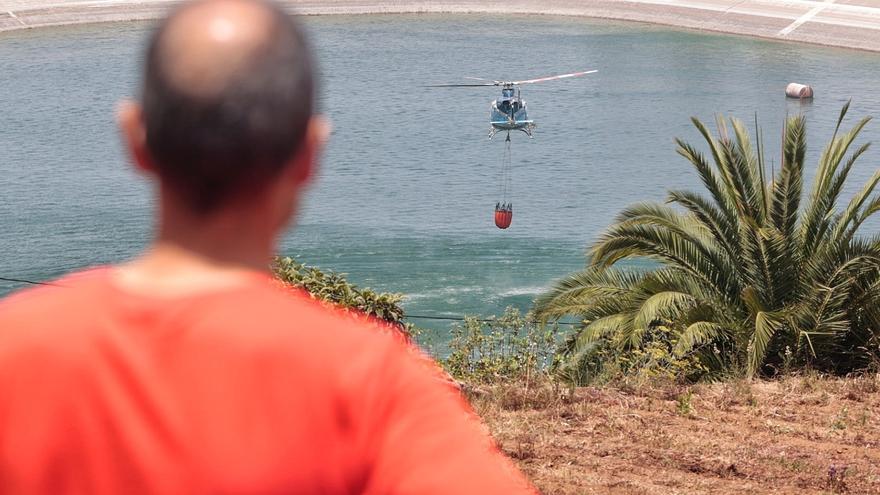 Un helicóptero del Gobierno de Canarias recarga agua en la balsa La Cruz Santa (Los Realejos) para apagar el incendio de Tenerife
