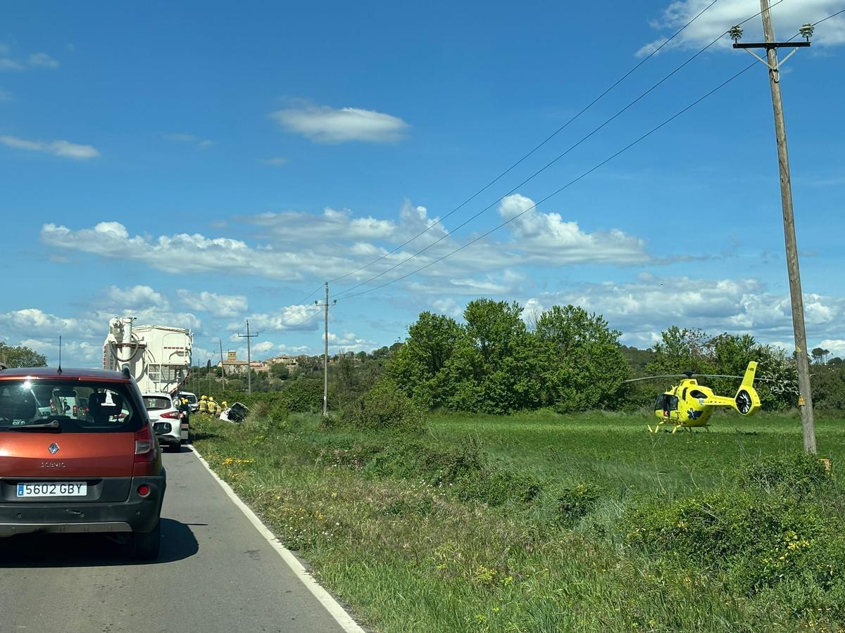 Vehicles fent cua arran del pas alternatiu per l'accident de Colomers i a la dreta, l'helicòpter medicalitzat del SEM.