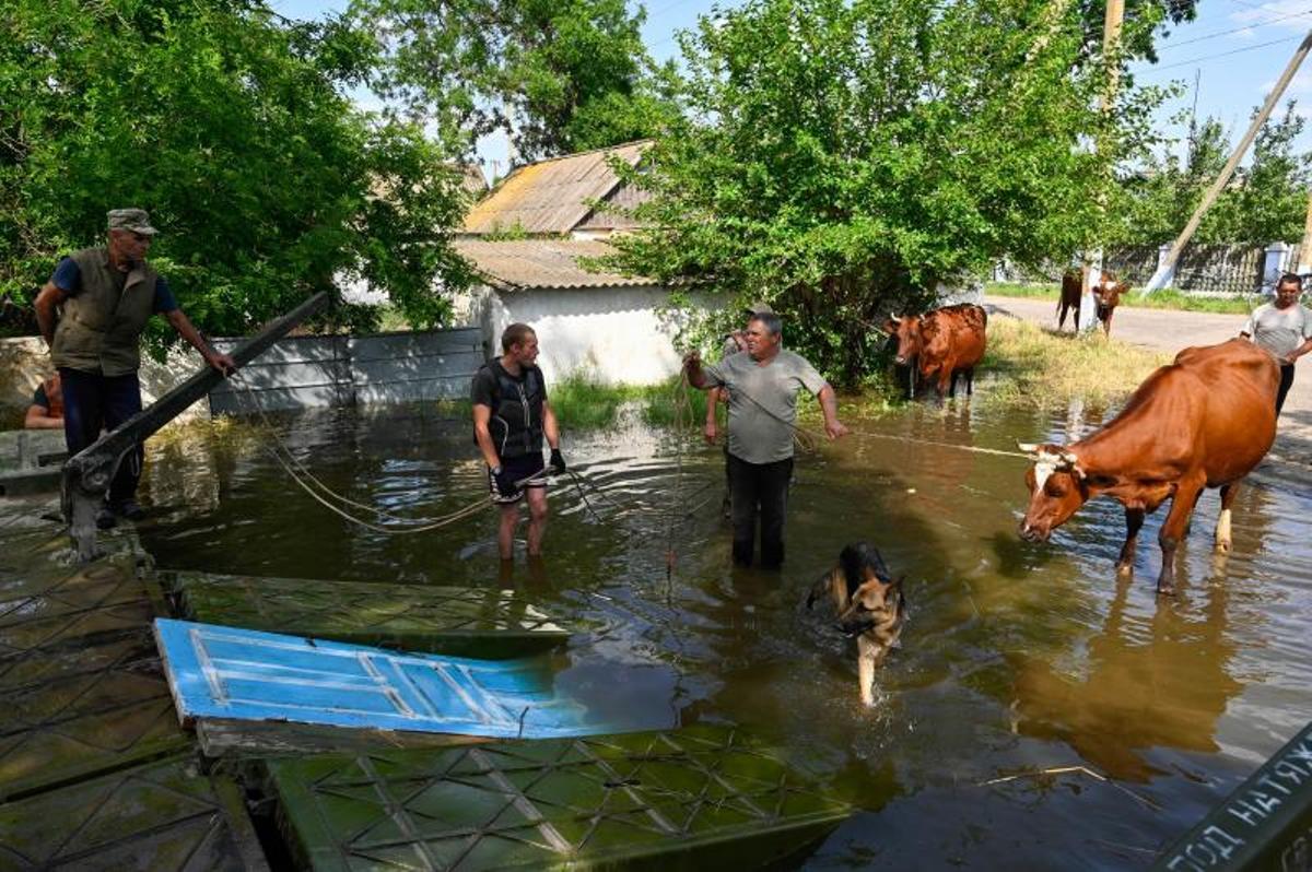 Los voluntarios entregan alimentos a los residentes locales en un área inundada, en medio del ataque de Rusia a Ucrania, en Kherson