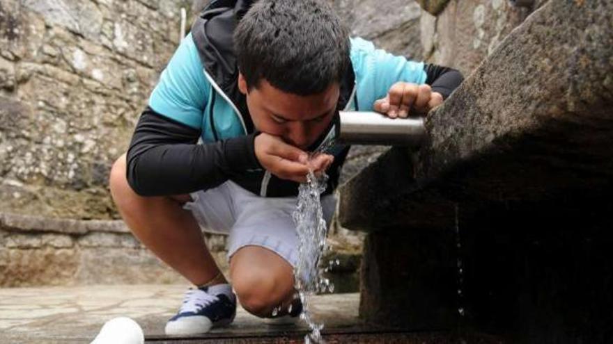 Un joven bebe agua de la fuente de Santa Xusta en Moaña. / gustavo santos