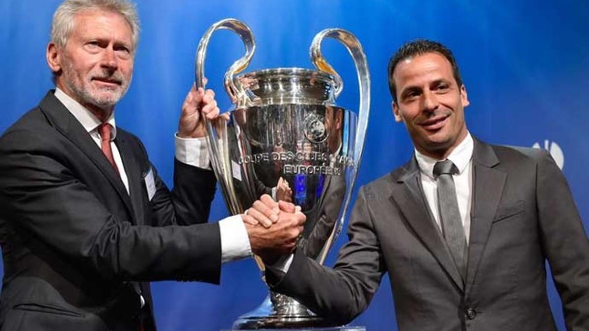 Paul Breitner y Ludovic Giuly posan con la Champions tras el sorteo