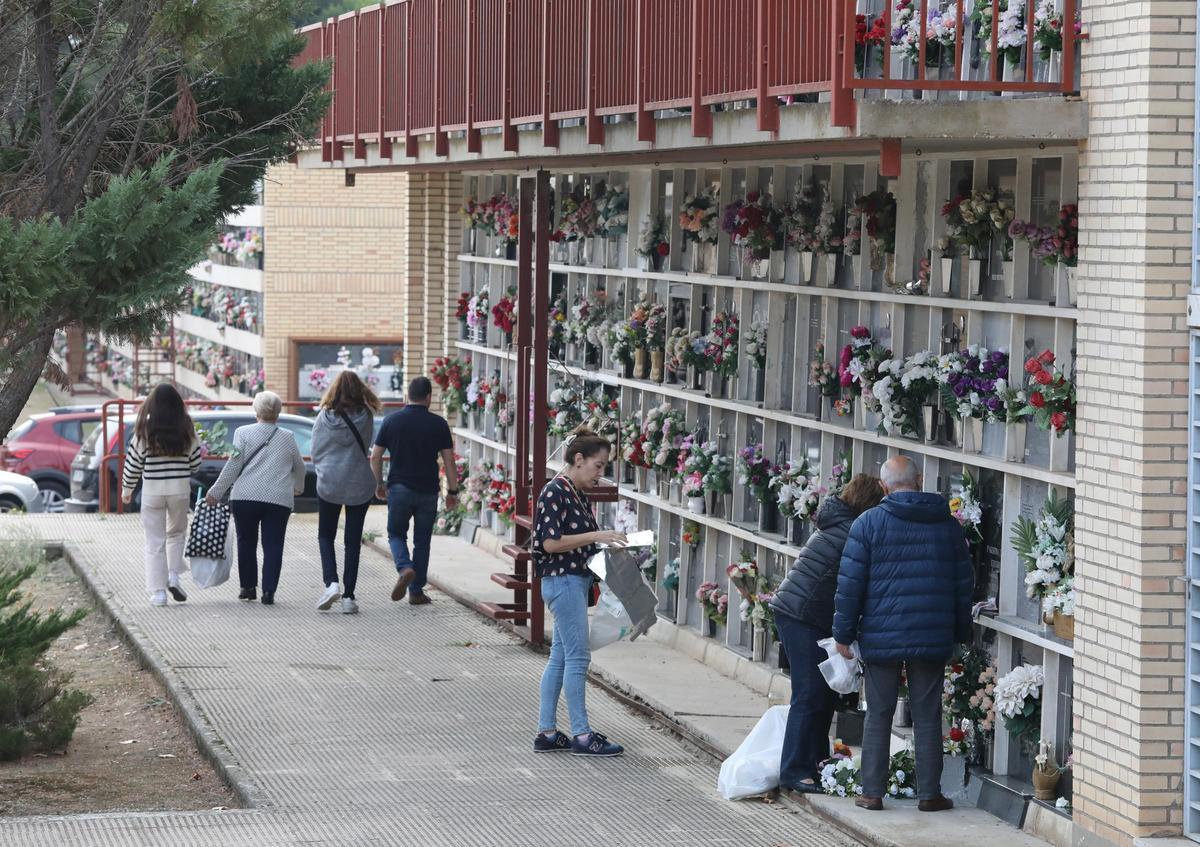 Familiares visitan las tumbas de sus seres queridos el Día de Todos los Santos.