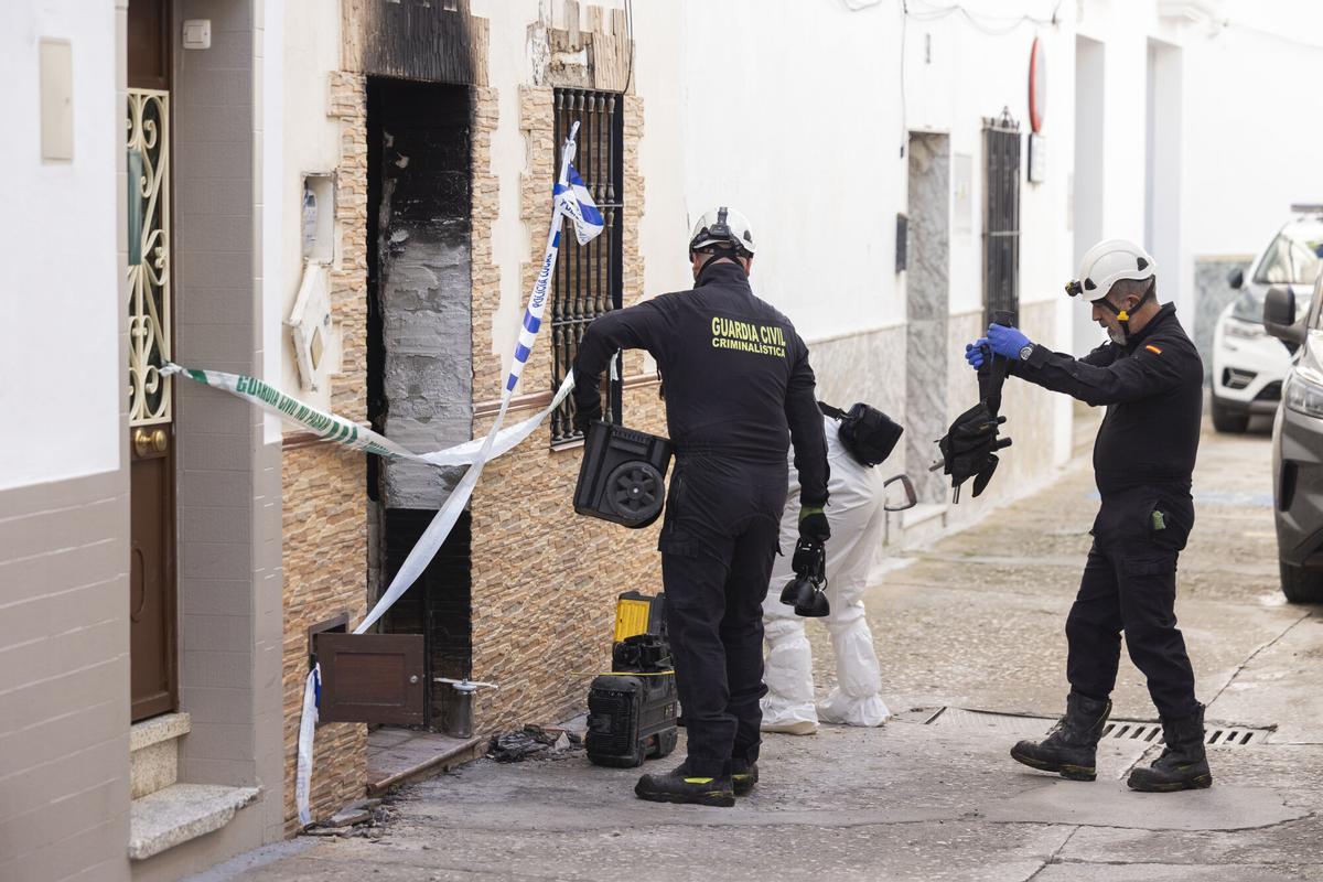 Un agente de criminalística de la Guardia Civil junto a la vivienda de Alhaurín el Grande, donde dos menores de 15 y 16 años, fallecieron en un incendio.