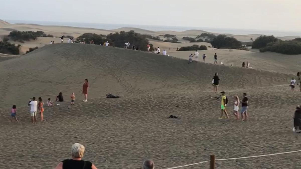 Decenas de personas en las crestas de las Dunas y zonas de acceso prohibido para ver el atardecer.