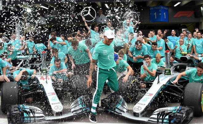 El piloto británico de Mercedes, Lewis Hamilton (C) celebra con el equipo de Mercedes después de ganar el Gran Premio de F1 de Brasil y obtener el título de constructores en el circuito de Interlagos en Sao Paulo, Brasil