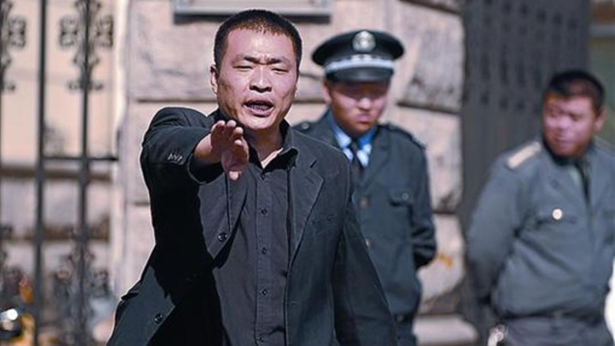 Un policía impide tomar fotos ante la casa de la mujer de Liu Xiaobo.