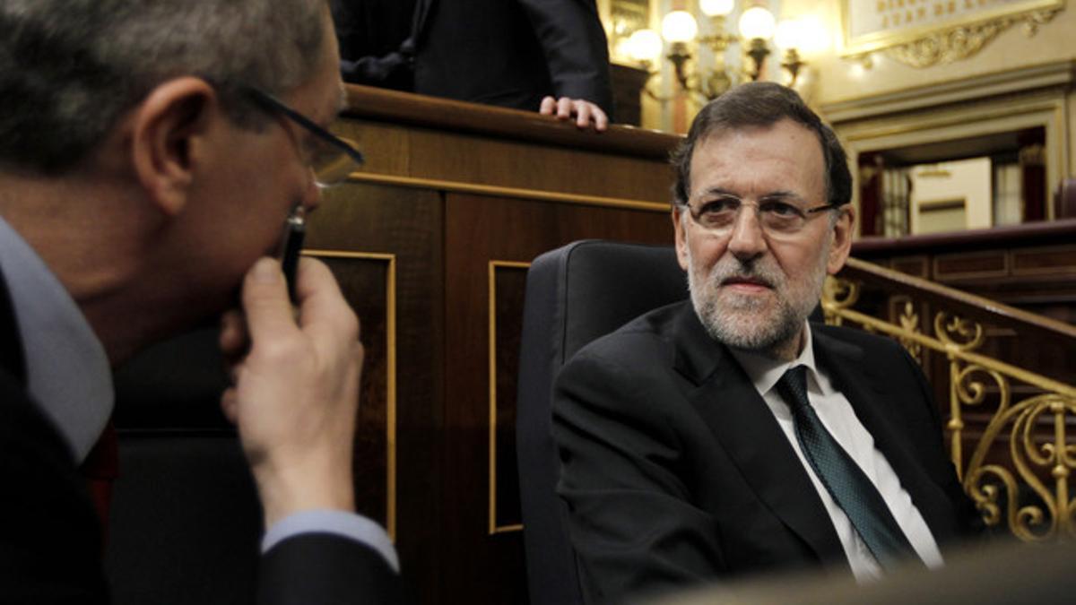 Alberto Ruiz-Gallardón habla con Mariano Rajoy, este miércoles en el Congreso.