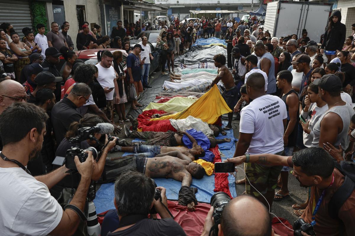 ATENCIÓN EDITORES: CONTENIDO GRÁFICO EXPLICITO ACOMPAÑA CRÓNICA: BRASIL DROGAS AME3085. RÍO DE JANEIRO (BRASIL), 29/10/2025.- Personas observan cuerpos sin vida en una calle este miércoles, en Río de Janeiro (Brasil). El megaoperativo del martes, en el que participaron 2.500 agentes, tenía como objetivo detener a cabecillas del Comando Vermelho, una de las organizaciones criminales mas antiguas y peligrosas de Rio. EFE/ André Coelho. ATENCIÓN EDITORES: CONTENIDO GÁFICO EXPLICITO ACOMPAÑA CRÓNICA: BRASIL DROGAS