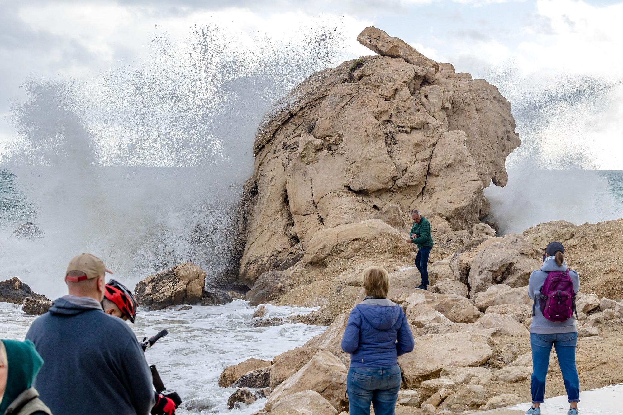 Turistas y paseantes observan el temporal de mar en la Cala de Finestrat