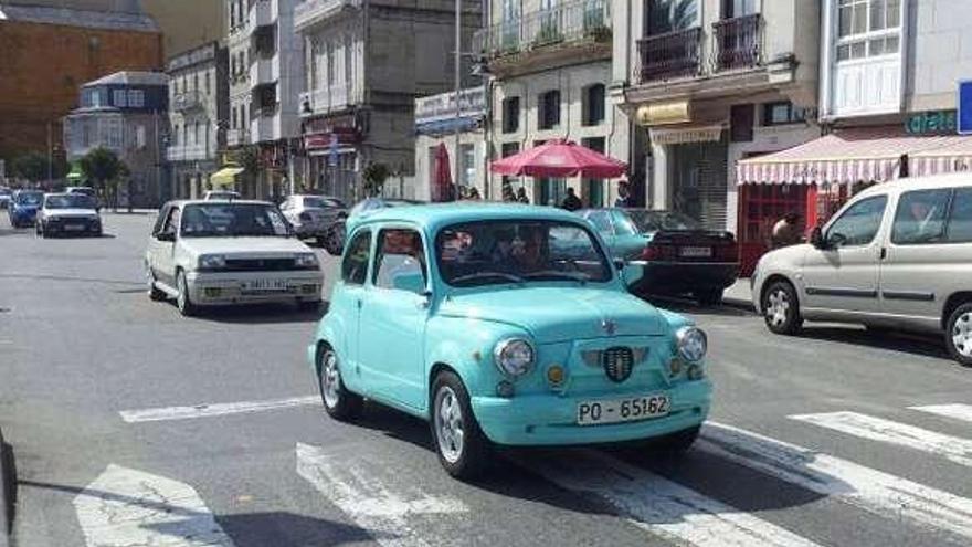 Arriba, la exposición de vehículos antiguos al lado de la plaza de abastos de Moaña. Abajo, la ruta por el casco urbano de la villa.  // G.Núñez