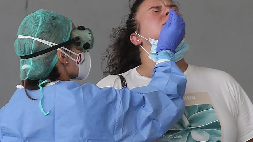 Una enfermera toma una muestra a una paciente para un test de covid