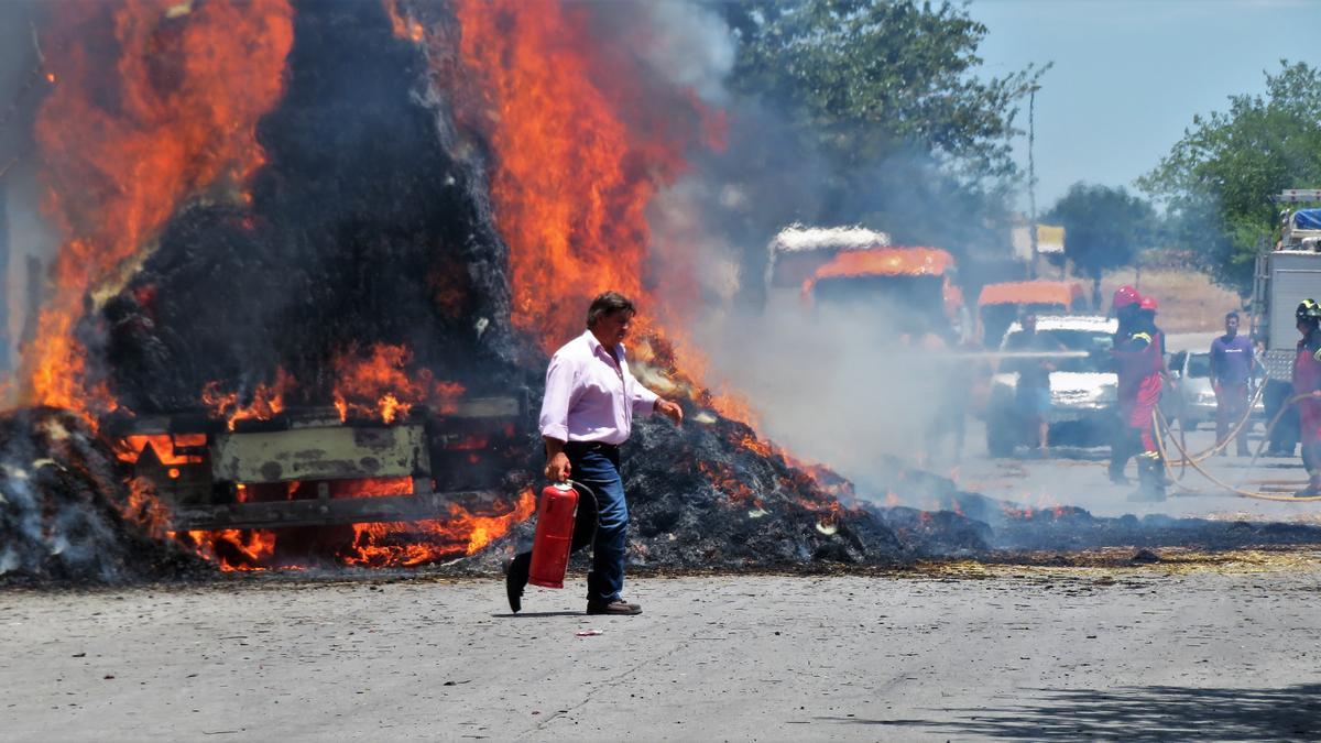 Un vecino corre con su extintor para ayudar a apagar las llamas