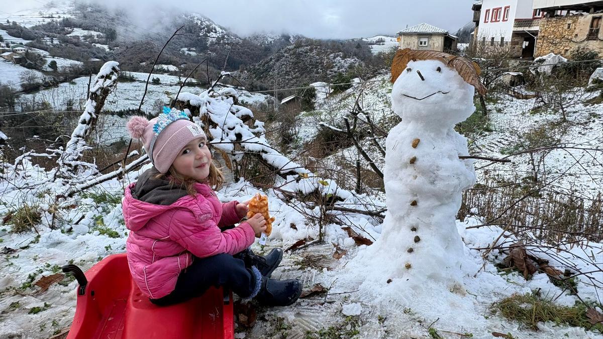 Emma Teixeira con su muñeco de nieve en Combarcio (Tineo).