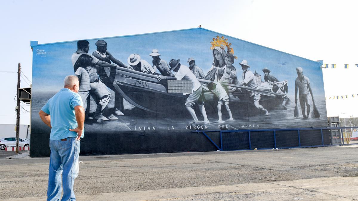 Un vecino de Arguineguín contempla el nuevo mural pintado en la fachada lateral de la cofradía de pescadores.