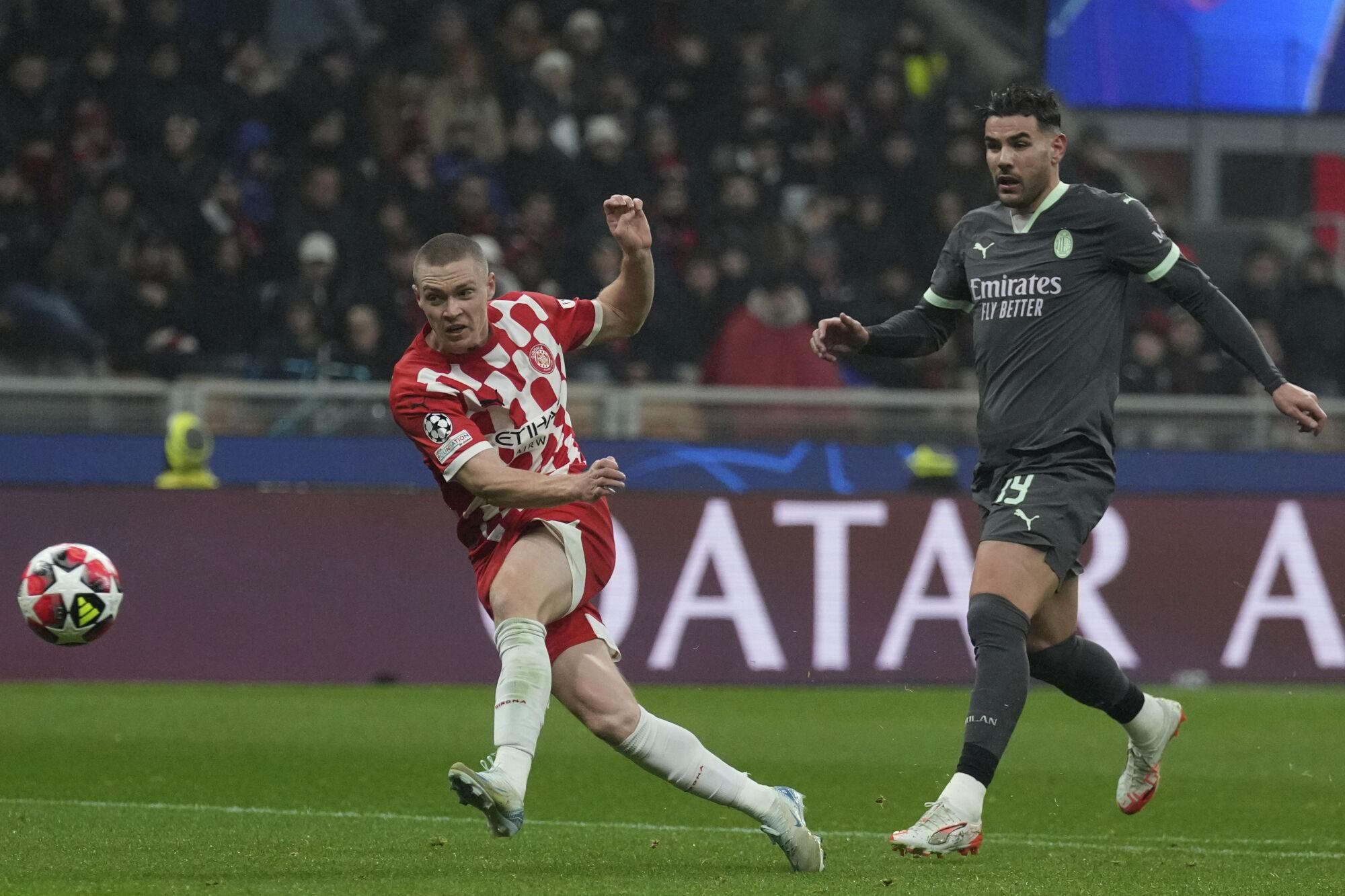 Girona's Viktor Tsygankov, left, shoots on goal during the Champions League opening phase soccer match between AC Milan and Girona at the San Siro stadium in Milan, Italy, Wednesday, Jan. 22, 2025. (AP Photo/Antonio Calanni). EDITORIAL USE ONLY/ONLY ITALY AND SPAIN