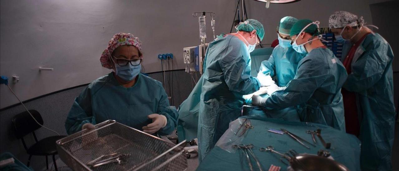 Varios cirujanos en un quirófano durante una intervención.
