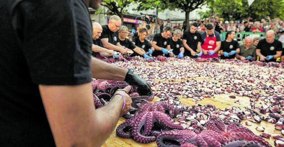 Uno de los pulpeiros cortando rodajas de los tentáculos. | // BRAIS LORENZO