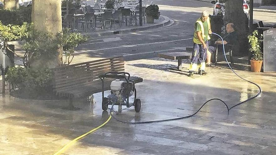 Un operario realiza la limpieza de la calle con agua a presión.