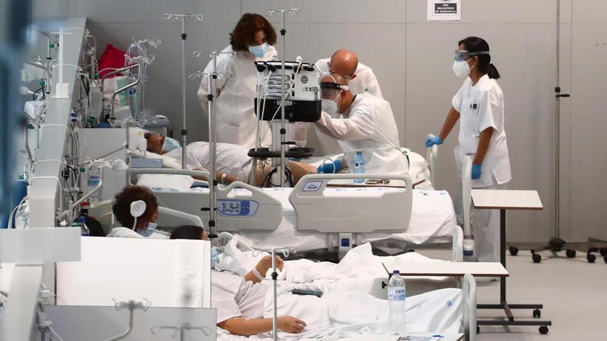 Unos doctores atienden este lunes a un paciente con coronavirus en el Hospital Enfermera Isabel Zendal en Madrid.