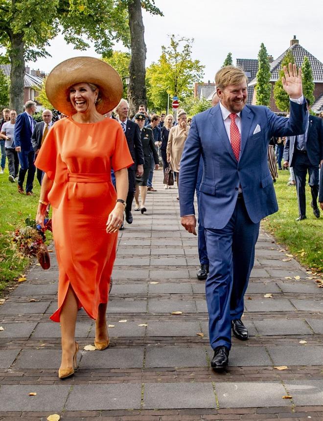 El look de la reina Máxima de Holanda con vestido naranja, pamela de rafia y salones de tacón