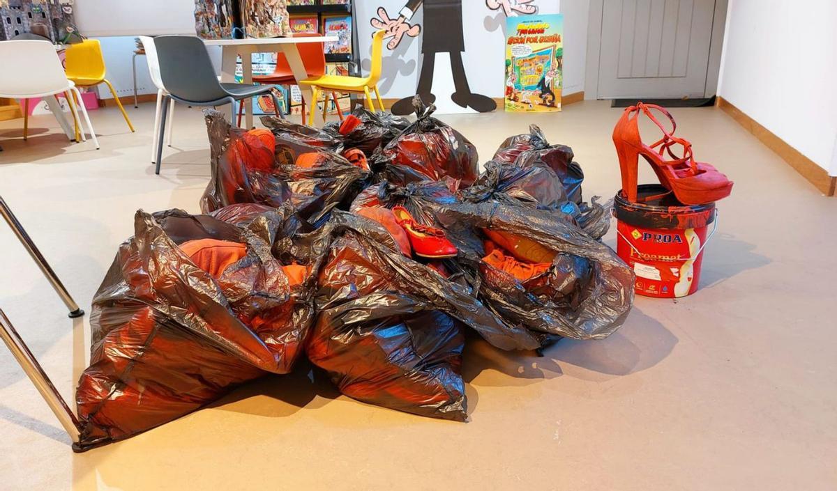 En A Illa, la exposición de zapatos rojos simboliza a las mujeres asesinadas por esta lacra. |  FdV