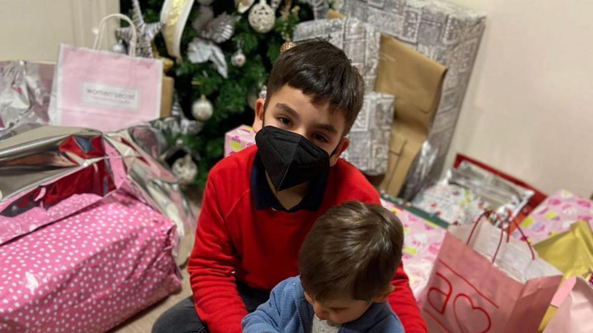 Dos pequeños a punto de abrir sus regalos. |   /BERNABÉ/ANA AGRA