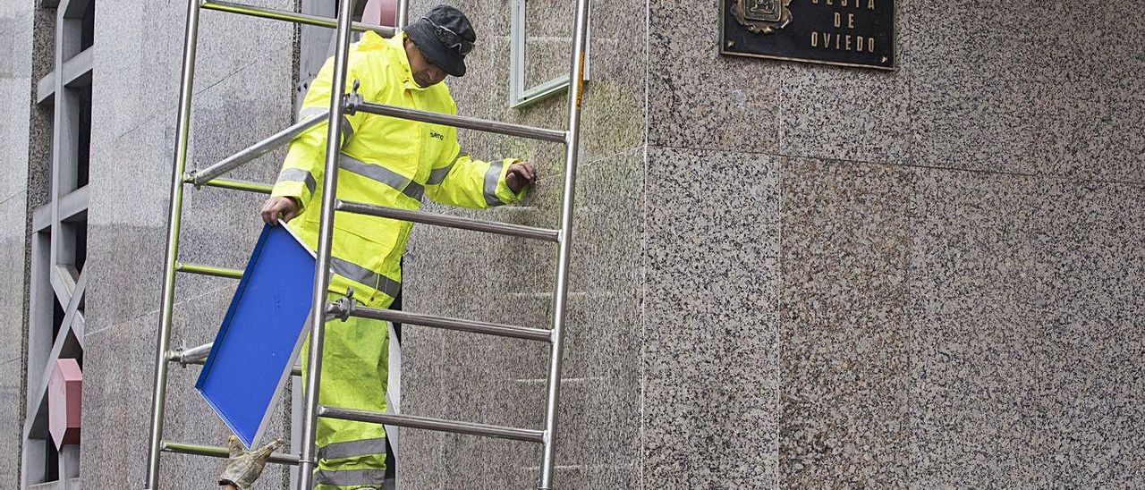 Operarios retirando la placa de la calle Calvo Sotelo.