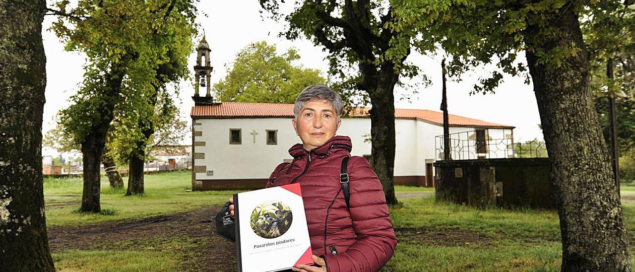 Isabel García amosa un dos exemplares do seu libro na carballeira do Montserrat.  | // BERNABÉ/JAVIER LALÍN