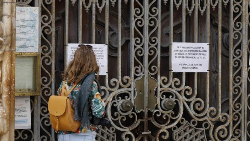 Una persona observa un cartel en la entrada del Museo Nacional de Cerámica.
