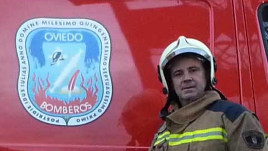 Eloy Palacio, junto al escudo de los bomberos de Oviedo.