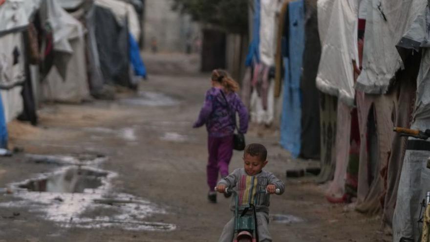 Un nen condueix el seu tricicle per un carreró d’un improvisat  campament per a desplaçats palestins a Deir al-Balah, a Gaza, ahir. | ABDEL KAREEM HANA / AFP