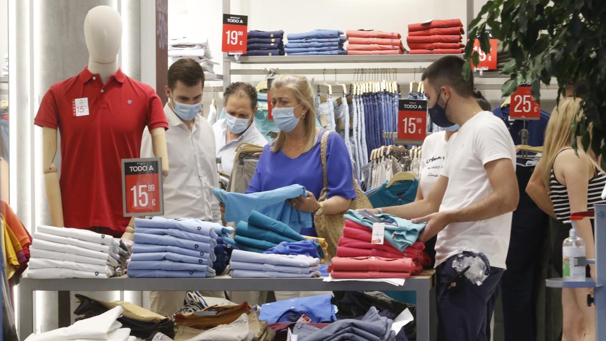 Varias personas comprando en un comercio de ropa en Córdoba capital.