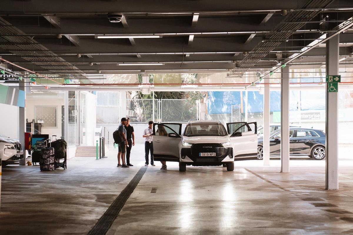 Usuarios de uno de los servicios de alquiler de coches de la estación de Atocha de Madrid recogen su vehículo.