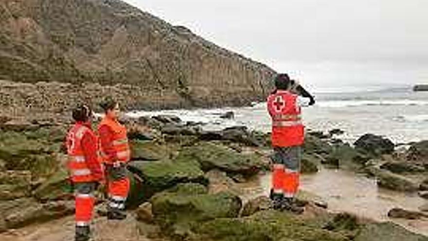 Miembros de Cruz Roja rastrean la Playa del Sablón, en Llanes.
