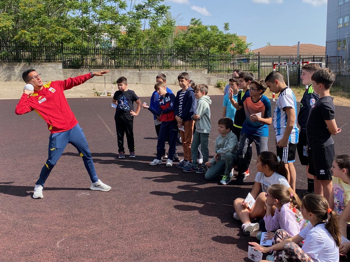 Benabbou simula un lanzamiento de peso, una de las pruebas de atletismo.