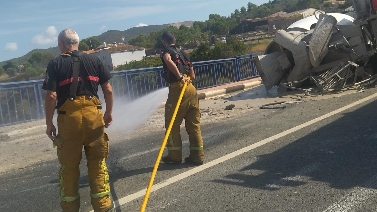 Los bomberos están limpiando el hormigón vertido en la calzada