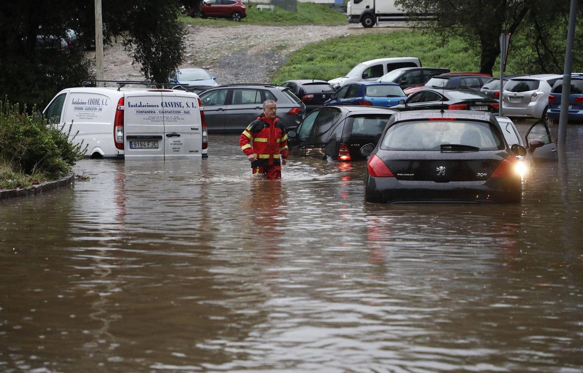 Varios coches atrapados en una balsa de agua que se formó en la rotonda que lleva de Fontiñas a Fontes do Sar