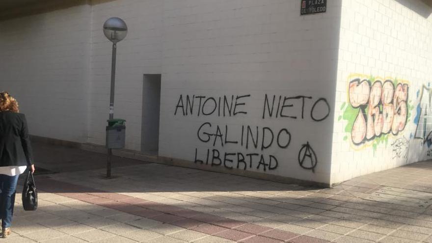 Una señora pasa por delante de una pintada de apoyo a Nieto Galindo en Murcia.