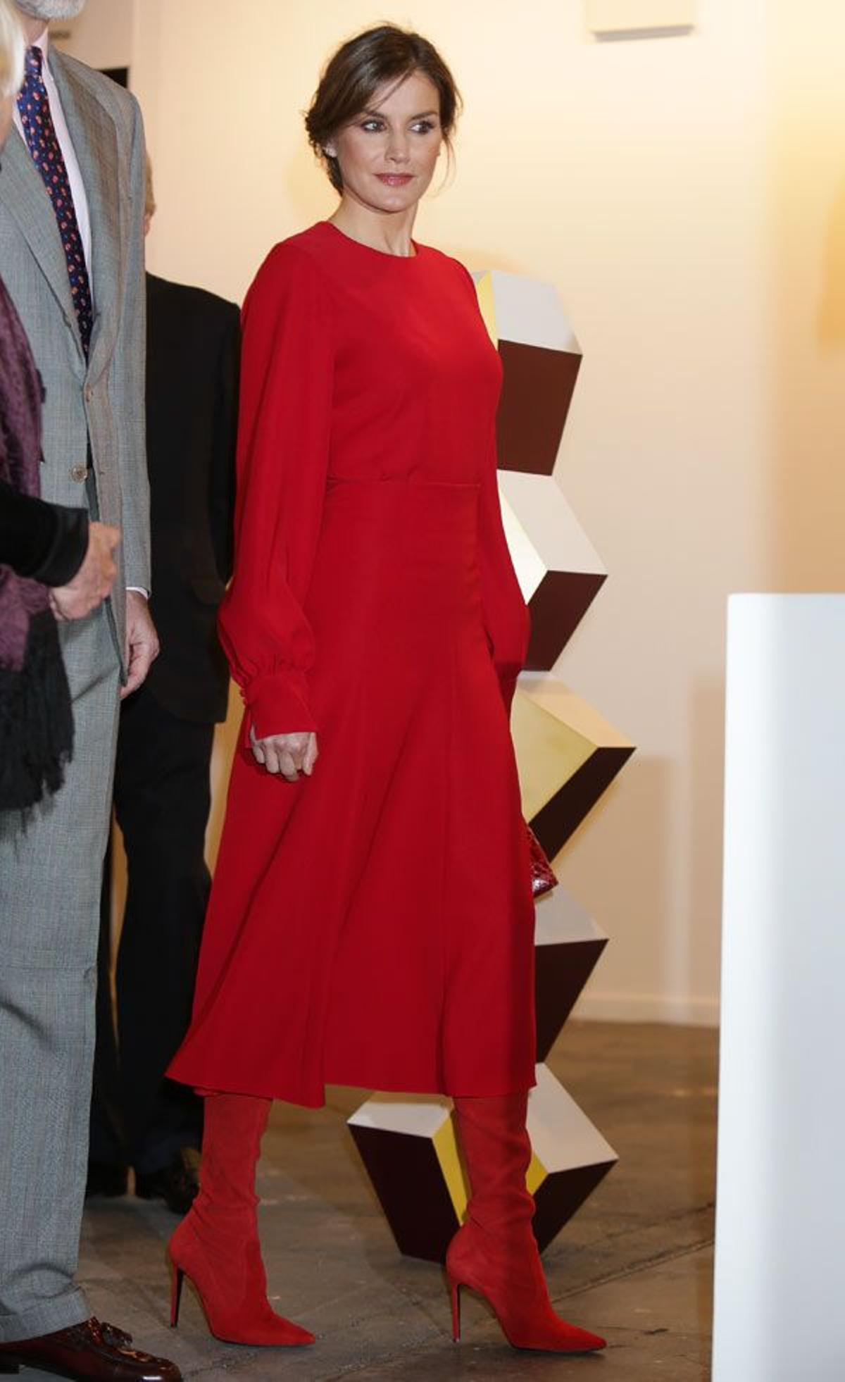 Letizia Ortiz con moño bajo y look de color rojo con botas altas en ARCO