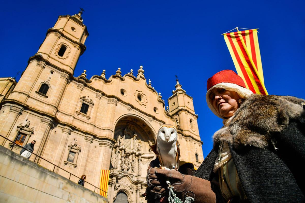 Una mujer sosteniendo en su brazo una lechuza en la Concordia de Alcañiz