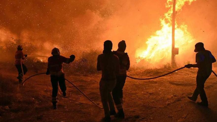 Vecinos ayudan a los bomberos a extinguir las llamas de uno de los incendios de la región de Viseu.