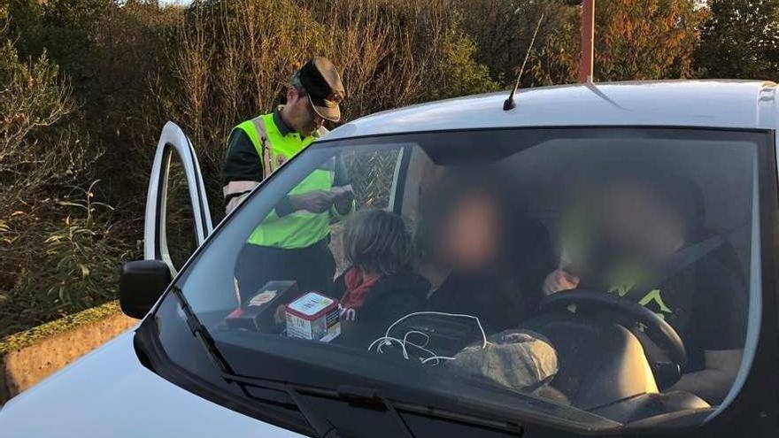 Un niño sin silla de retención infantil en el regazo de su madre, durante la campaña de vigilancia de furgonetas.