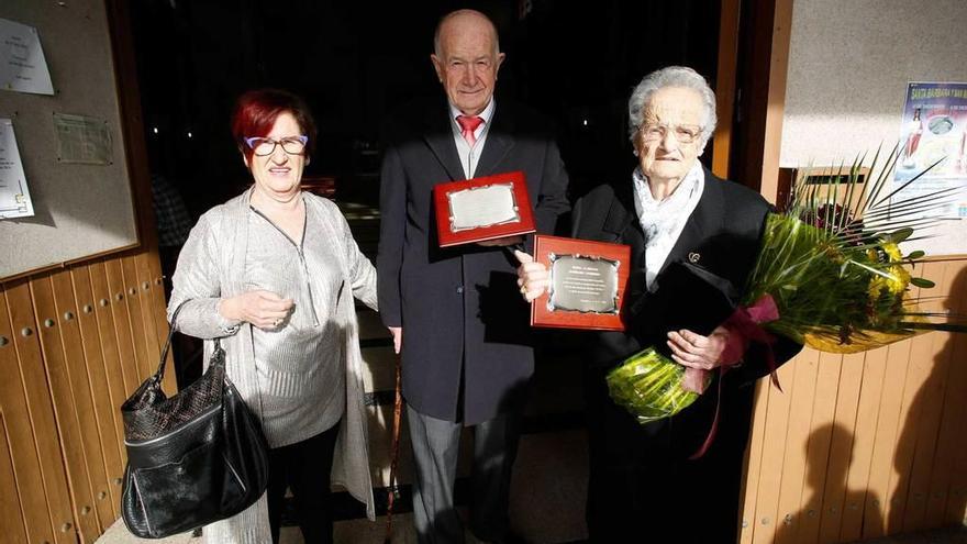 Esther García, presidenta vecinal, junto a José Indalecio Granda y a María Ascensión Rodríguez, ayer, con sus placas a la puerta de la iglesia de Bañugues.