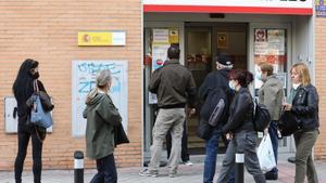 Varias personas en la puerta de una oficina del SEPE.