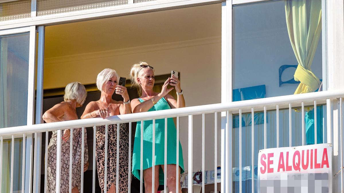 Tres turistas en el balcón de una vivienda en Benidorm.