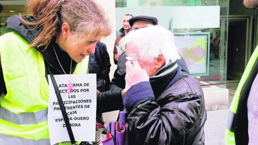 Una afectada se seca las lágrimas en la protesta de ayer frente a la sucursal de Caja España en Santa Clara.