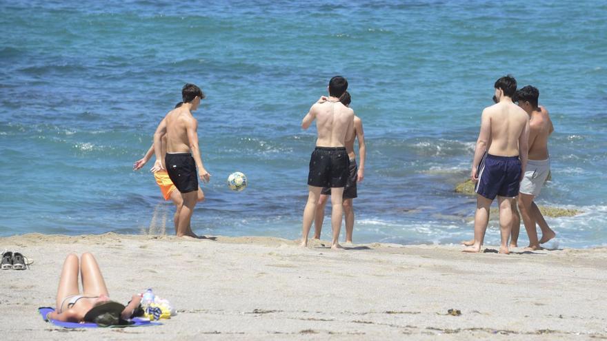 Un grupo de jóvenes juega al fútbol, este jueves, en la playa de Riazor.