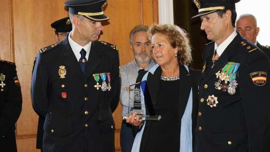 Adelina García, con la placa de reconocimiento a su marido, el cabo de la Policía Local José Aurelio López, &quot;Herrera&quot;, junto al jefe del grupo operativo de la Comisaría de Luarca, Francisco García, y el comisario Abel Alberto Núñez.